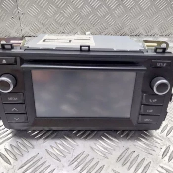 Car stereo head unit with a central touchscreen and labeled media, setup, and car/map controls on a metal diamond plate surface
